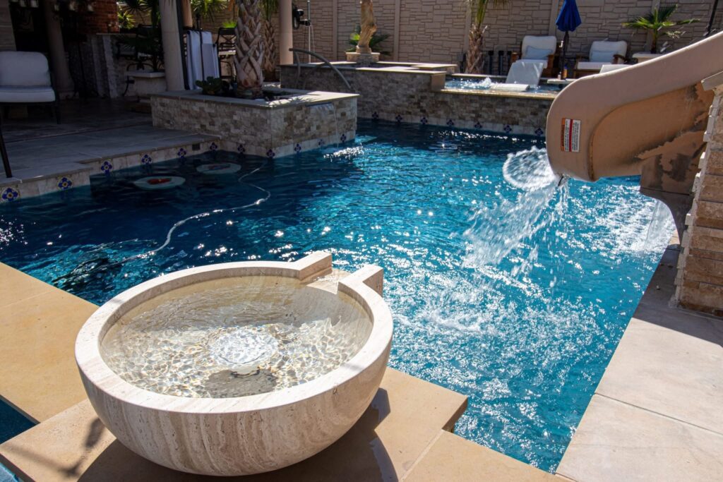 Finished pool with a slide as an upgrade plus and water feature. Outdoor Kitchen